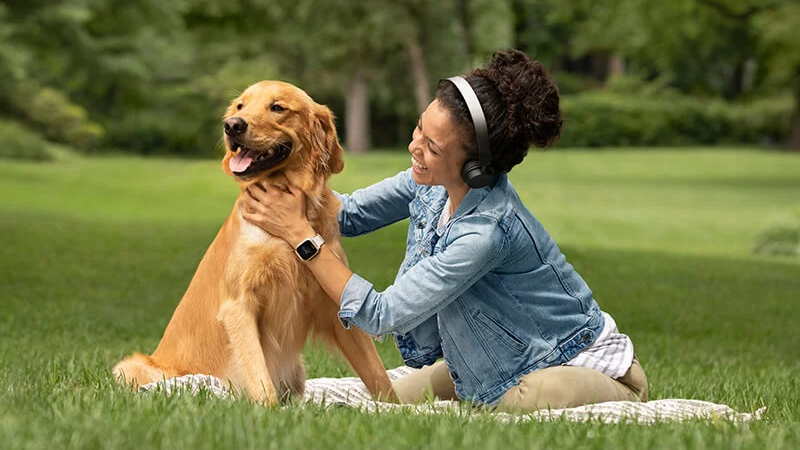 Donna con Garmin Venu sq mentre gioca con un cane